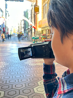 男の子が商店街を撮影している